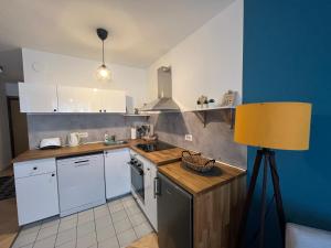 a kitchen with white cabinets and a yellow lamp at Cosy apartment - Zagreb Downtown with own parking spot in the garage in Zagreb