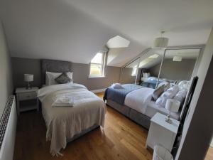 a bedroom with two beds and a large mirror at Dunquin House Bed and Breakfast in Dunquin