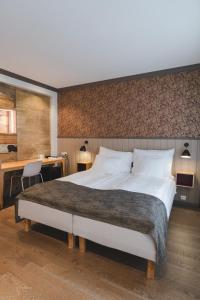 a bedroom with a large bed and a desk at Grand Hotel Egersund in Egersund