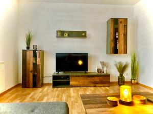 a living room with a flat screen tv and a table at Fewo Klöppel Auersbergblick in Eibenstock