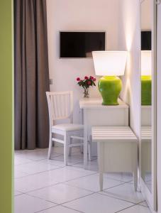 a table with a green vase on it next to two chairs at Tenuta Solomita in Maiori