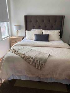 a bedroom with a large bed with a large headboard at Private Rooms in TownHouse w Shared Baths Qn Bed 1-3ppl in Unionport