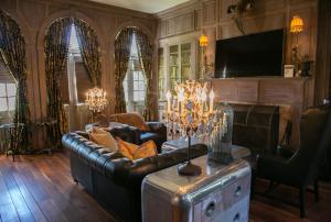 un soggiorno con divano in pelle e TV di The Inn at Tacaro Estate 