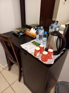 a table with a tea kettle and cups on it at فندق سرايا سيف مكة المحبس in Makkah
