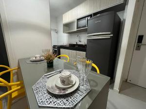 uma cozinha com uma mesa com uma chávena e pratos em Edifício Time Apto 306 ER Hospedagens em Maceió