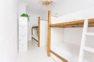 a bedroom with bunk beds and a ladder at La Cocotera Boutique Hostel & Coworking in Tarifa