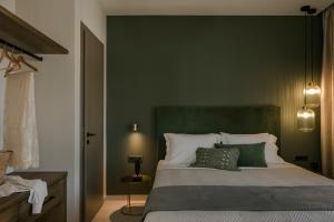 1 dormitorio con 1 cama grande y paredes verdes en Anthemis Living en Argostoli
