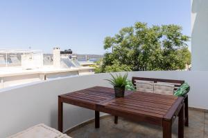 una mesa de madera en un balcón con vistas en Blue Port in Chania, en Suda