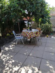 a table and chairs on a patio under a tree at Los Laguitos in Santiago