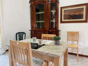 cocina con mesa y mueble de porcelana en Aria di casa affittacamere, en Badesse