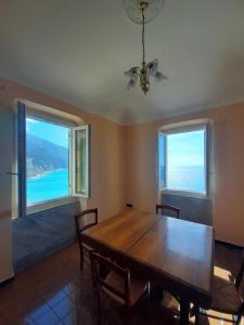 - une salle à manger avec une table en bois et 2 fenêtres dans l'établissement Camogli vista mare, à Camogli