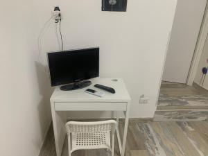 einen Computermonitor auf einem weißen Schreibtisch mit Stuhl in der Unterkunft SWEET HOME - tra Vesuvio, Sorrento e Napoli in San Giorgio a Cremano