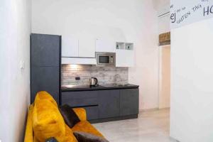 una cucina con divano giallo in soggiorno di COLOSSEUM LUXURY HOME a Roma