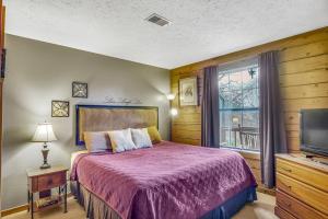 a bedroom with a bed and a tv and a window at 3 Bedroom Log Cabin Condo close to Everything! in Branson