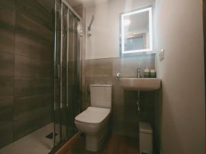 a bathroom with a toilet and a sink and a shower at Casa Pintáns in Cangas de Morrazo