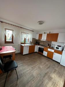 a large kitchen with a table and a counter top at Casa din Deal Crisbomir - BRAN in Predeluţ