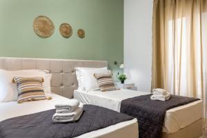 Blue Port in Chania في سودا: سريرين في غرفة نوم عليها مناشف