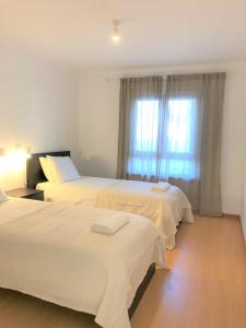 a hotel room with two beds and a window at Sea Avenue House - center Baleal - walk to surf in Ferrel