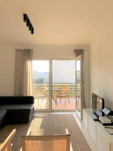 a living room with a couch and a sliding glass door at Sea Avenue House - center Baleal - walk to surf in Ferrel