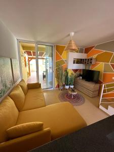 a living room with a yellow couch and a tv at Golden Beach House in Porto Santo