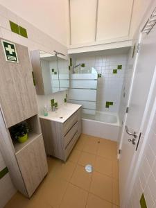 a bathroom with a sink and a tub and a mirror at Golden Beach House in Porto Santo