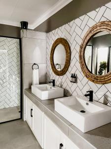a white bathroom with two sinks and a mirror at Battiss Guest House in Pretoria