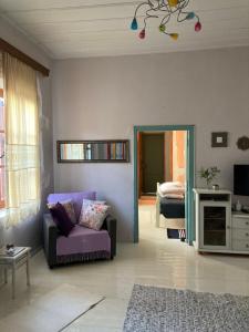 a living room with a purple couch and a bedroom at Sergios Village House in Chania