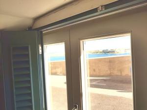 una stanza con due porte scorrevoli con vista sull'oceano di Ripple 23 Savynomad Harbour Residences a La Valletta