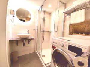 un bagno con lavatrice e lavandino di Ripple 23 Savynomad Harbour Residences a La Valletta