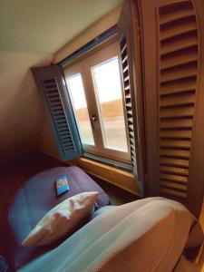 a bedroom with a bed with a pillow and a window at Ripple 23 Savynomad Harbour Residences in Valletta