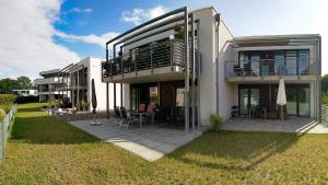 a large house with a deck and a patio at Ferienwohnung MeerZeit EG in Altefähr