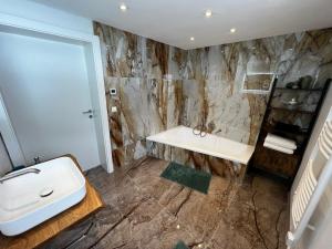 a bathroom with a sink and a bath tub at Haus Bergfeld with the view over Dachstein in Ramsau am Dachstein
