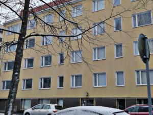 a building with snow covered cars parked in front of it at Pyynikin Rauha in Tampere