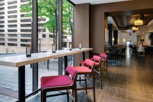 a bar in a restaurant with pink chairs at Courtyard by Marriott Atlanta Downtown in Atlanta