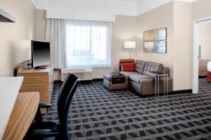 a living room with a couch and a tv at TownePlace Suites by Marriott Albany in Albany