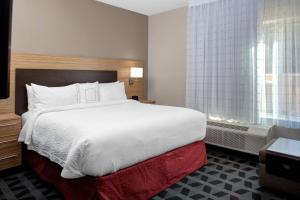 Habitación de hotel con cama grande y ventana en TownePlace Suites by Marriott Albany en Albany