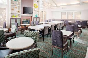 a dining room with tables and chairs and a tv at Residence Inn Dallas Park Central in Dallas