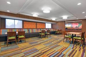 a waiting area with tables and chairs in a library at Fairfield by Marriott Inn & Suites Wallingford New Haven in Wallingford