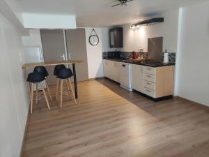 a kitchen with a table and stools in a room at Logement tout confort 6 personnes 