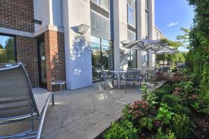 a patio with tables and chairs and an umbrella at SpringHill Suites Detroit Southfield in Southfield