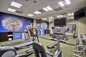 un gimnasio con cintas de correr y equipo cardiovascular y TV en SpringHill Suites Detroit Southfield, en Southfield