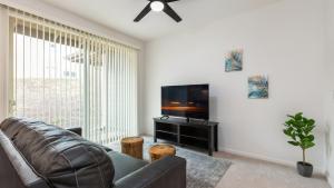 sala de estar con sofá y TV de pantalla plana en New Mountainside Home Near Spectacular Beaches, en Waianae