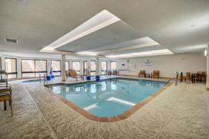 een groot zwembad in een hotel met stoelen en tafels bij Fairfield Inn & Suites by Marriott Springdale in Springdale