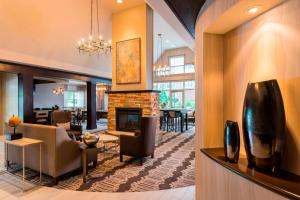 a living room with a fireplace and a dining room at Residence Inn Worcester in Worcester