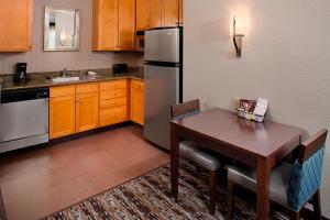 eine Küche mit einem Tisch und einem Kühlschrank aus Edelstahl in der Unterkunft Residence Inn Worcester in Worcester