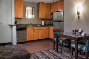 a kitchen with a table and a refrigerator at Residence Inn Worcester in Worcester