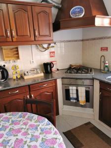 uma cozinha com um fogão e uma mesa em Silvia's House em Ponta Delgada