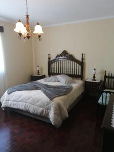 um quarto com uma cama grande e um lustre em Silvia's House em Ponta Delgada