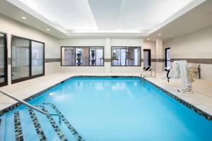 a large swimming pool with a large room with windows at Courtyard Worcester in Worcester