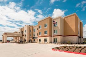 un edificio de oficinas con una bandera americana delante en Fairfield Inn & Suites by Marriott Fredericksburg Texas, en Fredericksburg